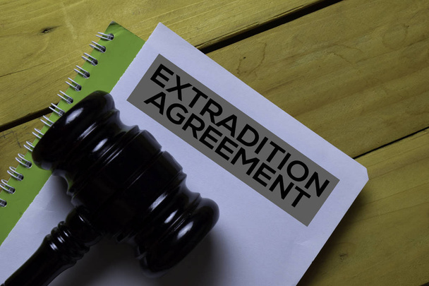 Extradition Agreement Document form and Black Judges gavel on wooden desk. Law concept